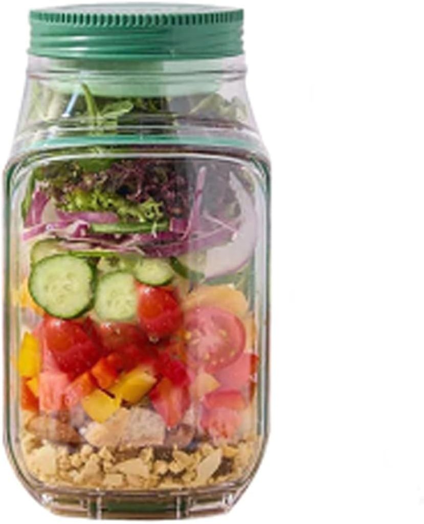 A glass jar filled with layered Harvest Salad ingredients—including chickpeas, chicken, bell peppers, tomatoes, cucumbers, onions, and leafy greens.