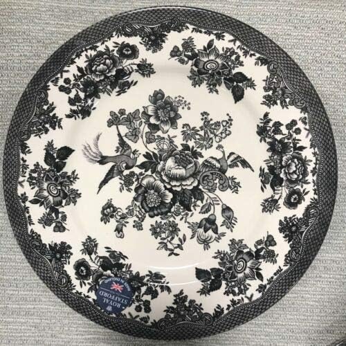 A decorative plate featuring a black and white floral and bird design with a patterned border, reminiscent of timeless wood charger plates. A sticker reads "Old Britain Castles by Johnson Brothers.