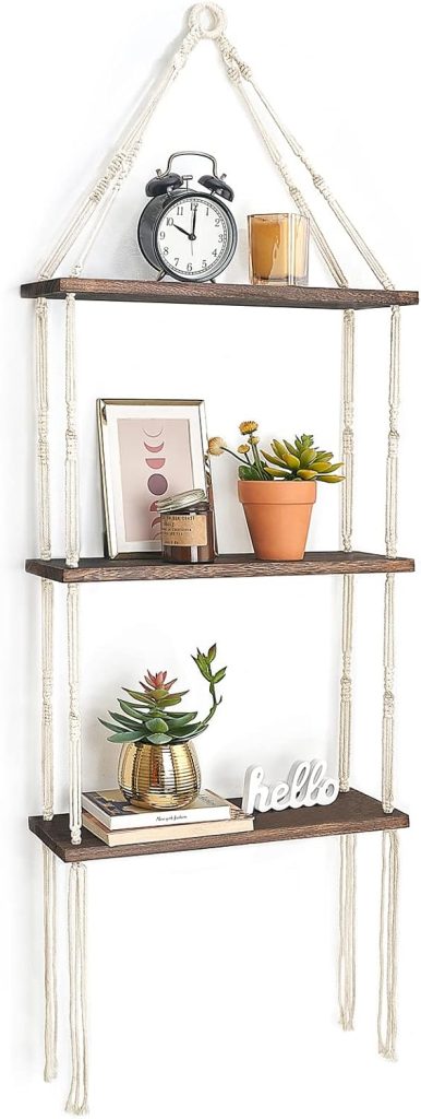 Three-tier hanging shelf with dark wood planks and white rope, perfect for displaying outdoor fall decor like candles, potted plants, a rustic clock, framed art, and a decorative "hello" sign.