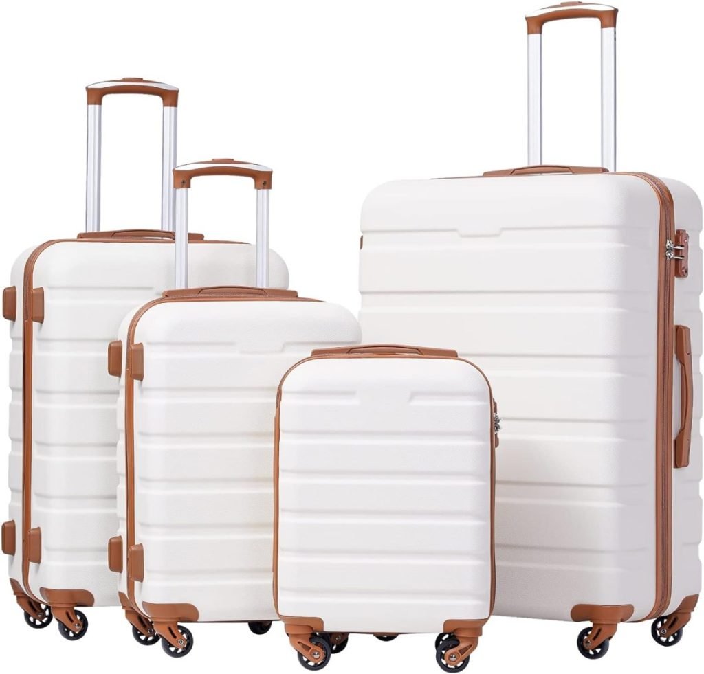 A set of four white suitcases with brown accents, varying in size, each with extended handles and four wheels.