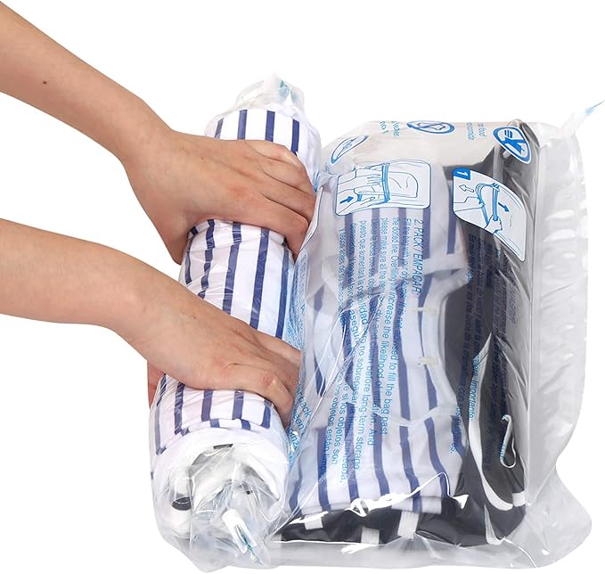 Hands are rolling a striped garment inside a vacuum-seal storage bag, with instructional images printed on the plastic bag visible.