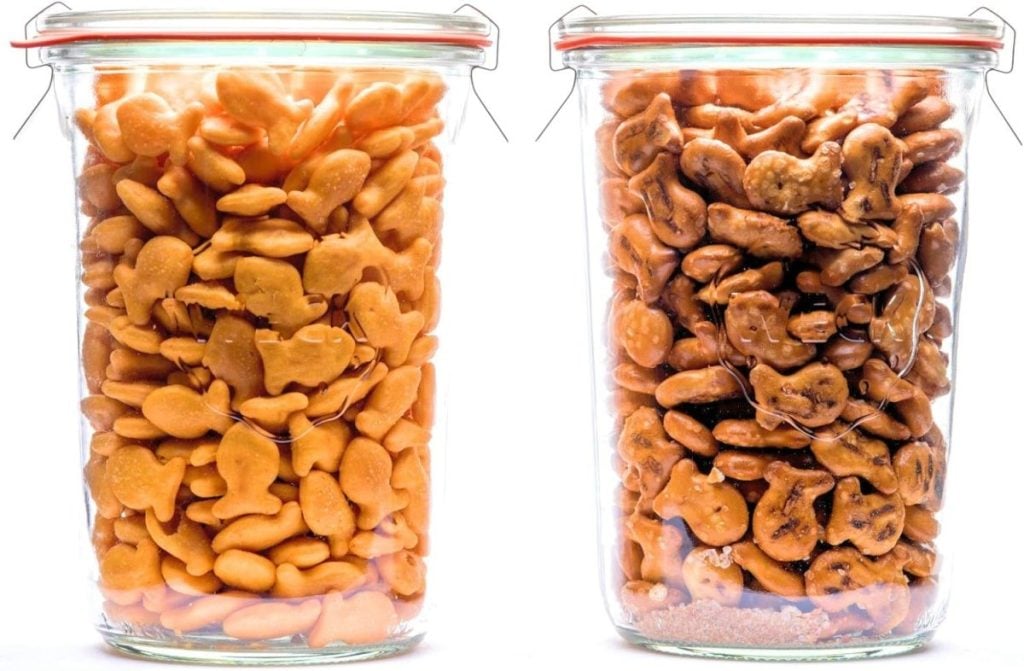 Two glass jars with metal clip lids; left jar is filled with goldfish-shaped crackers, right jar is filled with slightly burnt animal-shaped crackers.