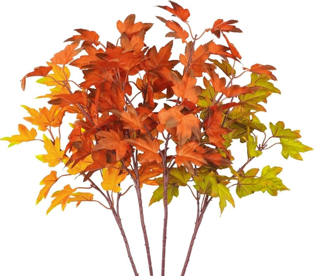 A bunch of artificial autumn leaves in various shades of orange, red, and green, attached to stems creates the perfect base for fall flower arrangements.