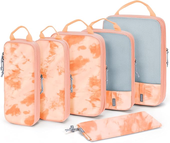 Five pink and white tie-dye packing cubes, varying in size, with zippers and handles, arranged neatly.