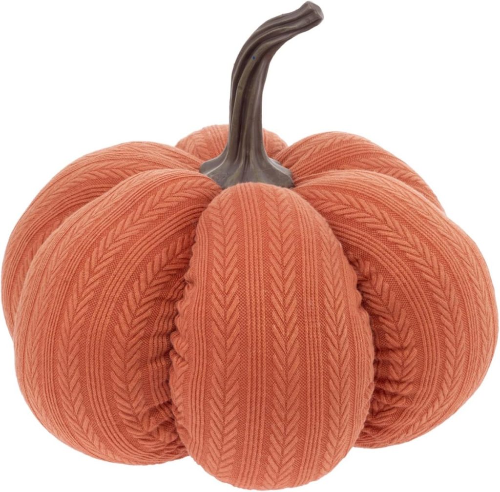 A decorative fall pumpkin featuring a textured, knitted orange fabric covering and a realistic brown stem.