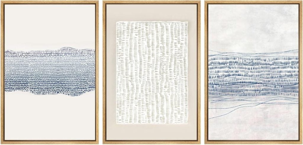 A triptych featuring three minimalist abstract paintings with blue and white linear patterns, framed in light wood. The designs vary in complexity, ranging from dense lines to sparser arrangements.