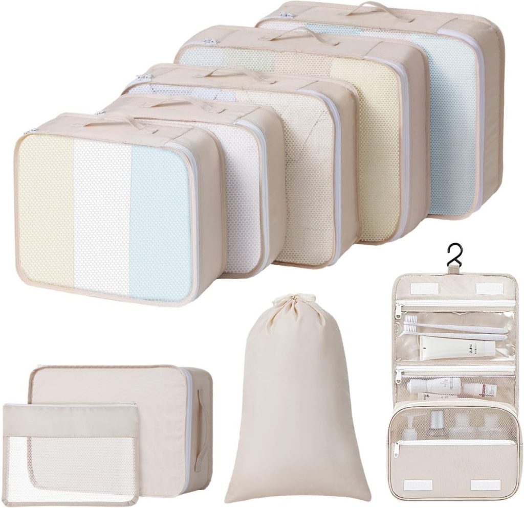 Set of beige travel packing cubes with mesh windows, including six cubes of various sizes, a drawstring bag, and a hanging toiletry bag with clear compartments.