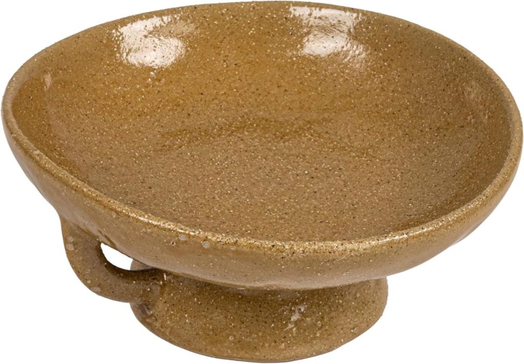 A shallow, round, brown ceramic bowl with a small handle and a wide footed base—perfect for serving or displaying your favorite pumpkin craft creations.