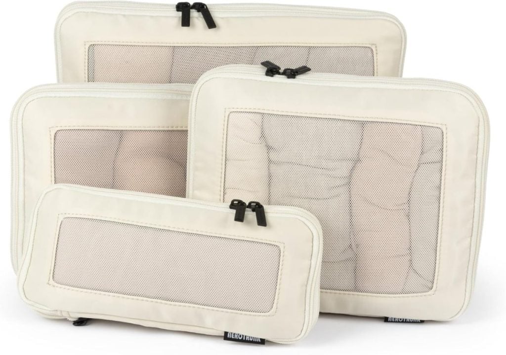 Four beige mesh packing cubes of varying sizes, each with a zipper closure and a transparent mesh panel on the front.