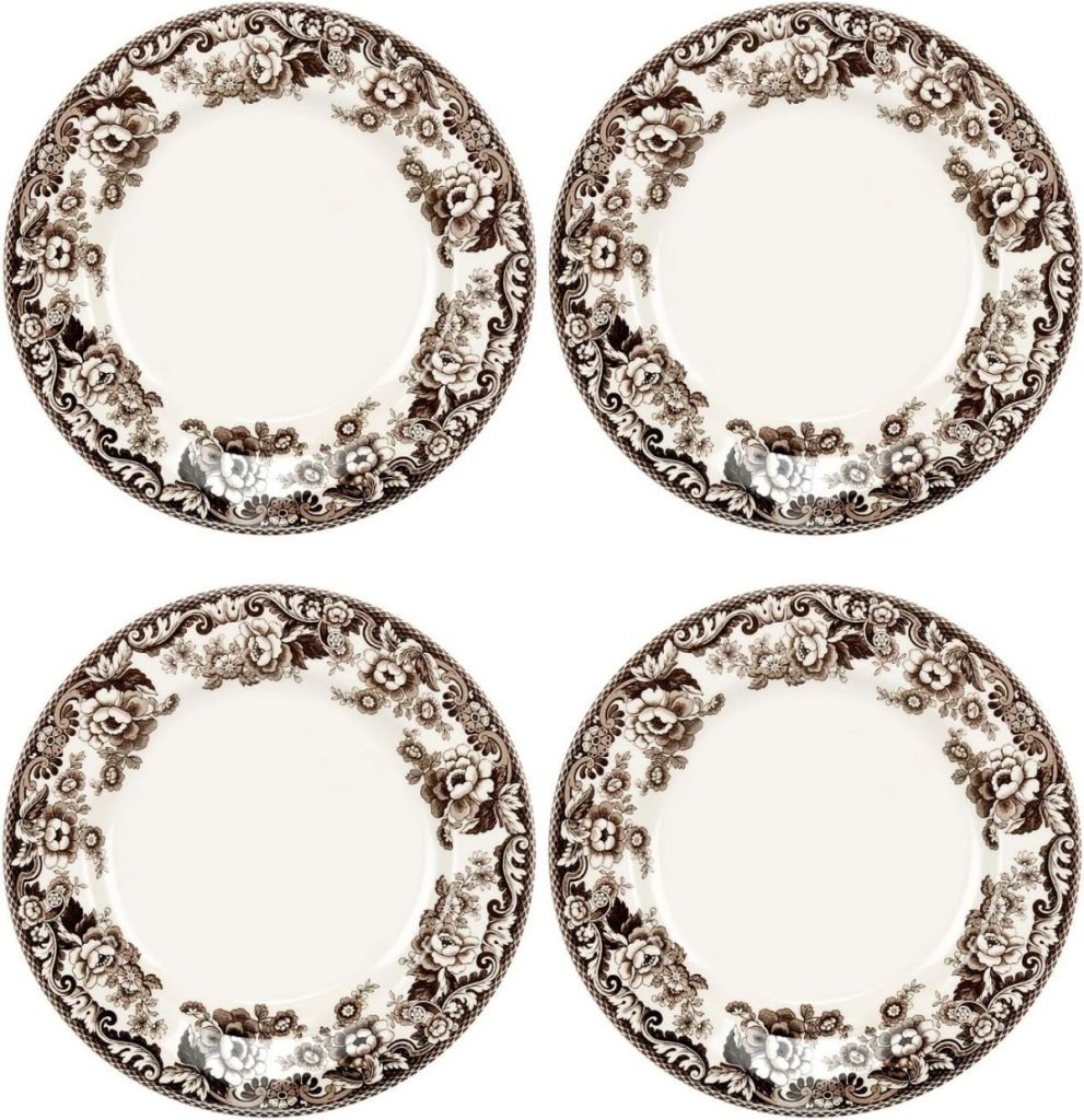 Four white porcelain plates featuring intricate brown floral and fruit patterns around the rims, perfect to complement your fall flower arrangements.