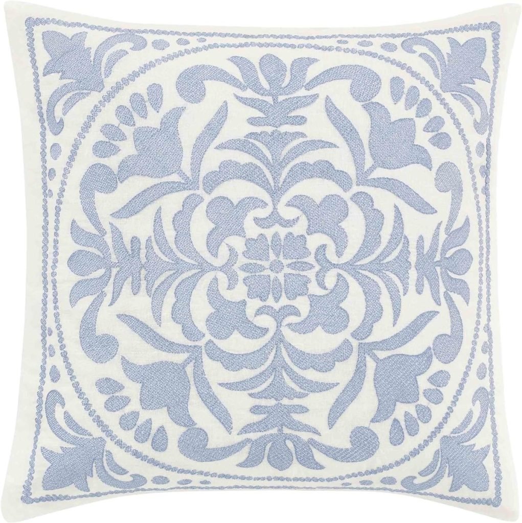 Square white pillow with an intricate blue floral and leaf embroidery design at the center.