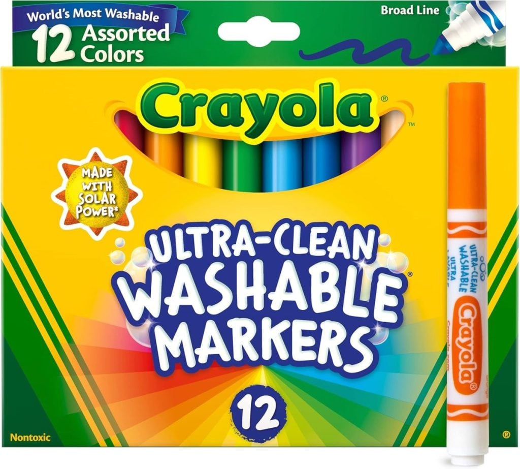 A box of Crayola Ultra-Clean Washable Markers with an orange marker placed in front. The box contains 12 assorted colors and highlights eco-friendly features.