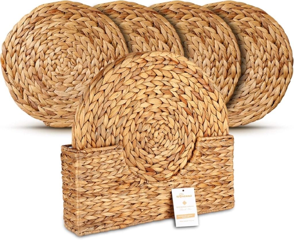 Set of four round, woven placemats in a natural, straw-like material, displayed with a rectangular matching holder and a product tag in front—perfect for complementing your fall flower arrangements.