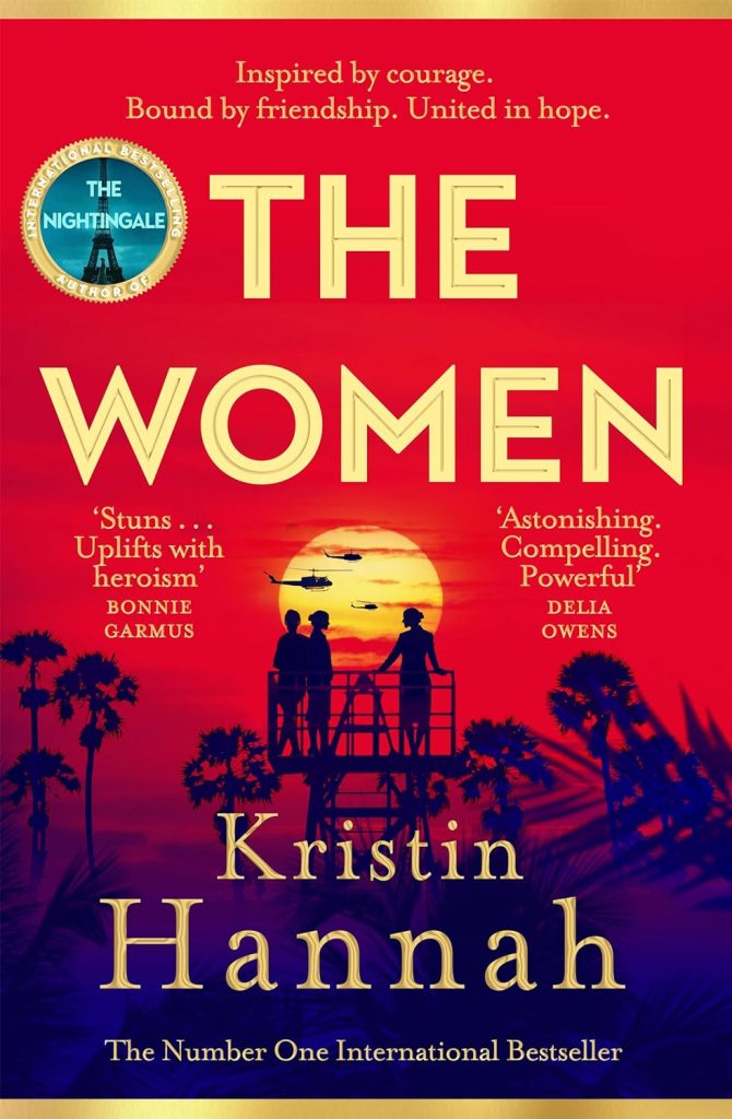 Cover of the book "The Women" by Kristin Hannah. The background features a sunset with silhouettes of people and helicopters. Plaudits from authors Bonnie Garmus and Delia Owens are displayed on the cover.