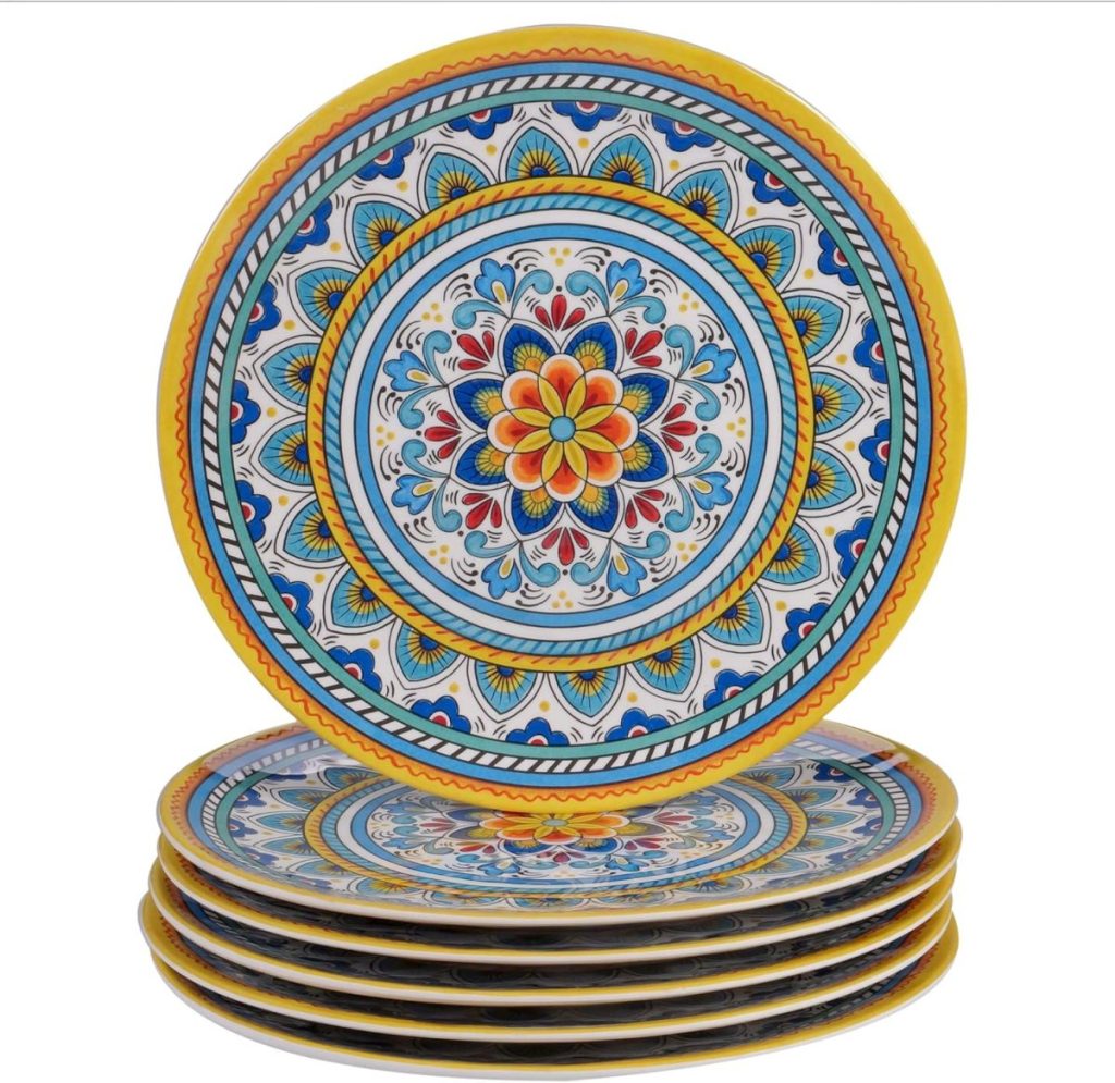 A stack of six round dinner plates features intricate, colorful geometric and floral patterns in blue, yellow, red, and white.