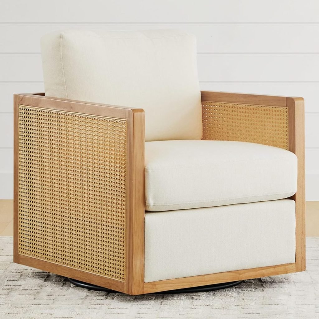 A beige cushioned chair with a wooden frame and cane detailing on the sides, placed on a light-colored rug in front of a white wall.