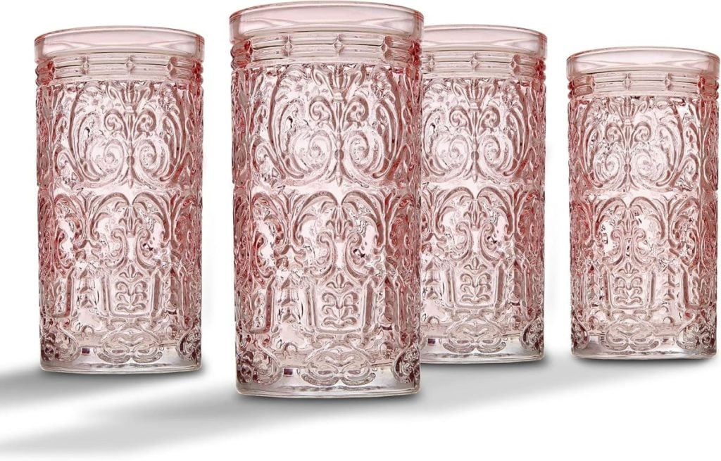 Four intricately patterned pink glass tumblers arranged in a row on a white background, reminiscent of the delicate beauty found in fall flower arrangements.