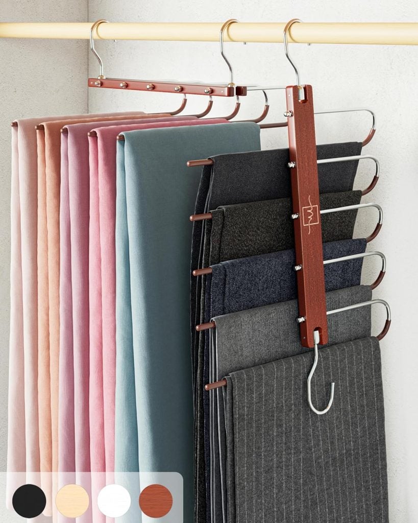 Multi-tiered metal hanger holding several pairs of trousers in various colors, hanging in a closet. Color swatches at the bottom left show black, beige, pink, and brown options.