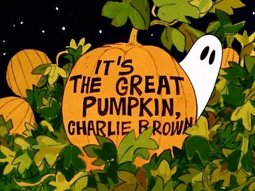 A pumpkin with the text "It's The Great Pumpkin, Charlie Brown" and a small ghost peeking from behind it, surrounded by leaves and smaller pumpkins.