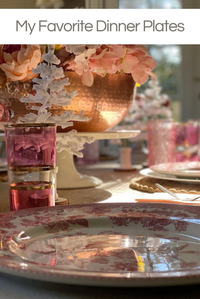 A table setting with floral-patterned dinner plates, pink decorative pieces, and a glass with a pink drink, under the text "My Favorite Dinner Plates.