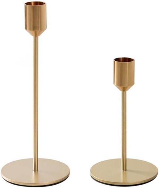 Two metallic candle holders of different heights with round bases and simple cylindrical designs.