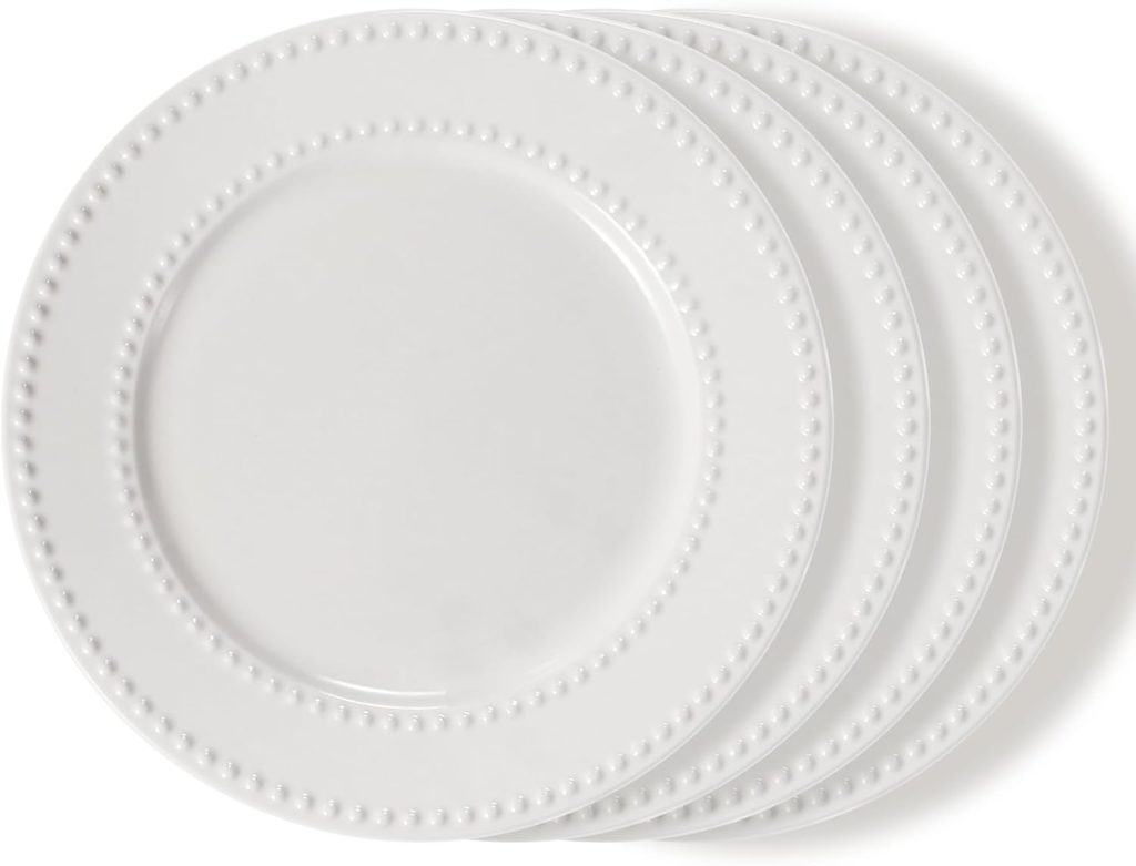 Four stacked white ceramic plates with a beaded rim design are arranged against a white background—perfect for serving up your favorite Friendsgiving ideas.