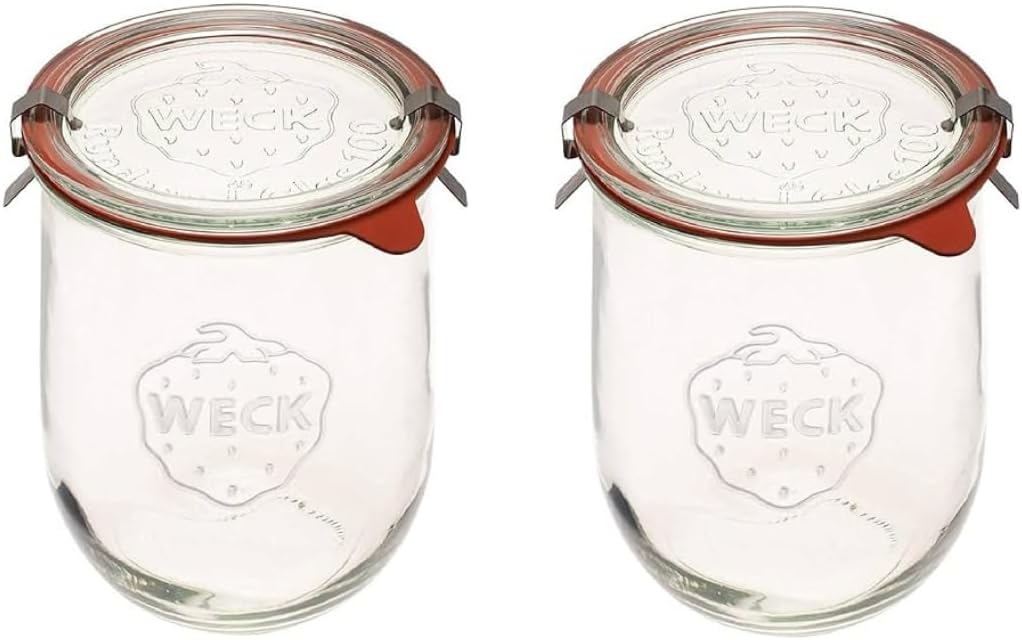 Two clear glass Weck jars with strawberry engravings and metal clips on the lids are shown side by side.