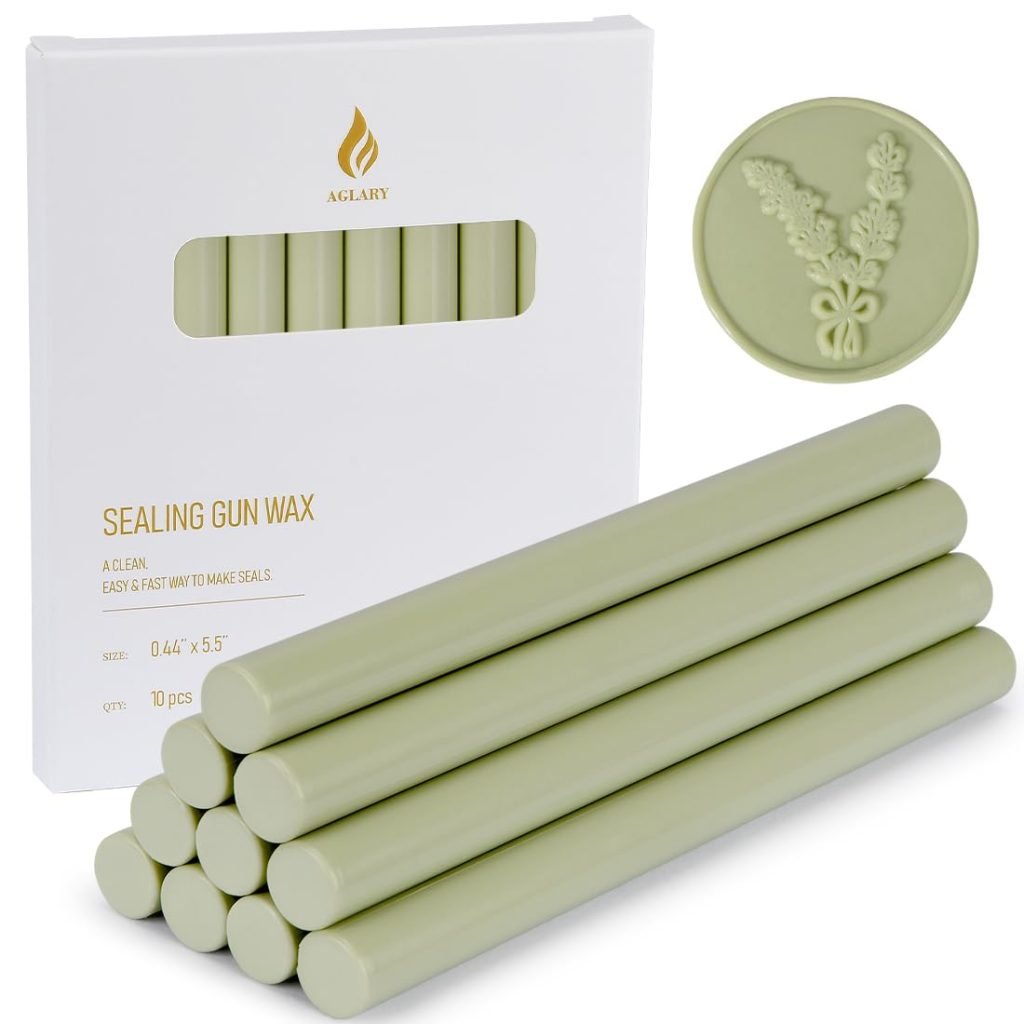 A box of sealing gun wax with several green wax sticks and a round seal featuring a floral design.