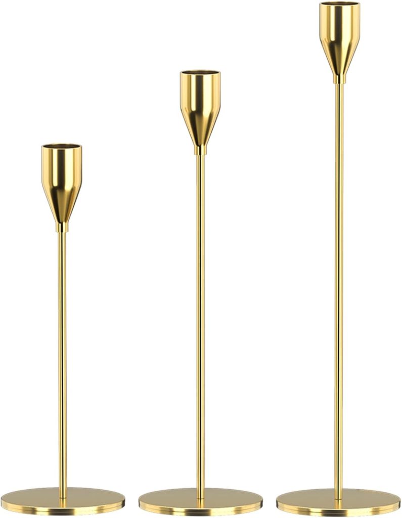 Three gold metal candle holders of varying heights stand side by side like elegant glass water bottles on flat bases.