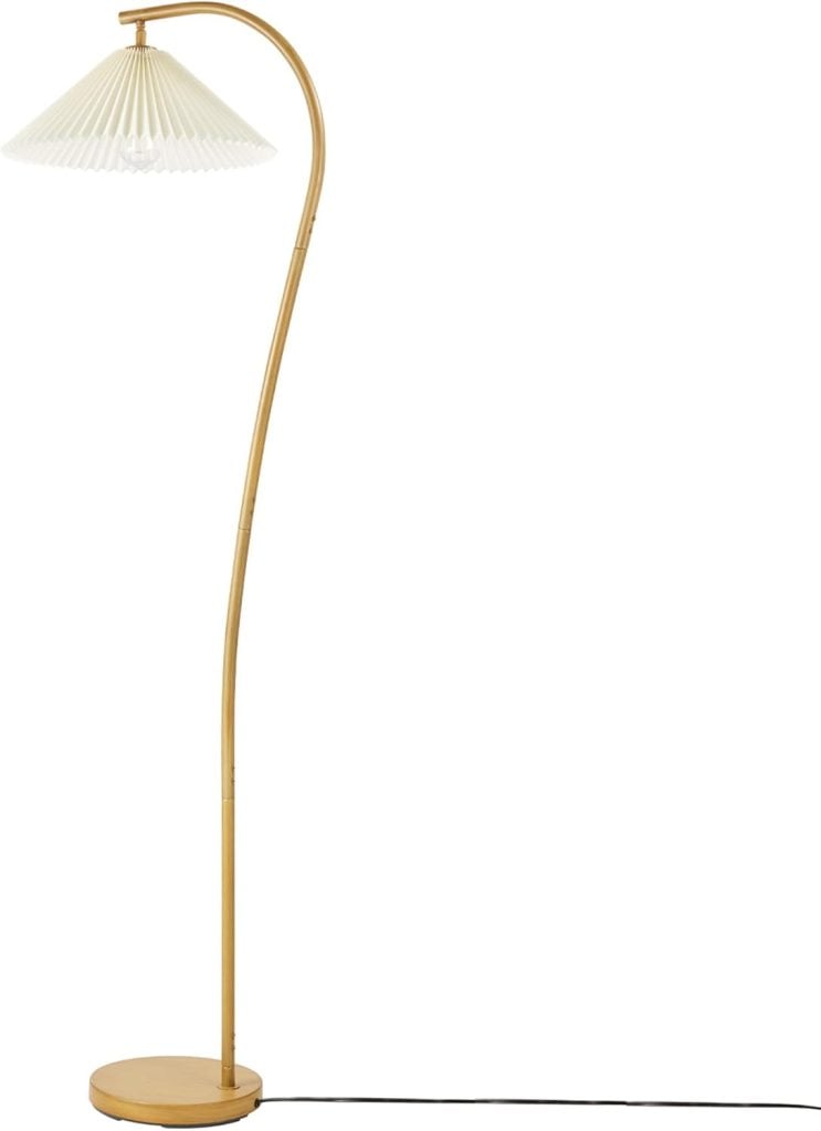 A floor lamp with a curved gold stem, a pleated white fabric shade, and a circular base. A black power cord extends from the base.