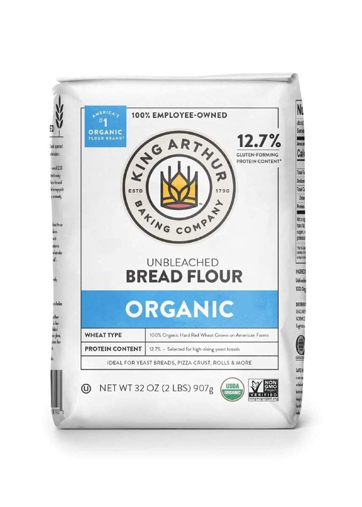 A 32 oz bag of King Arthur organic unbleached bread flour, featuring a blue label indicating 12.7% protein content and USDA organic certification.