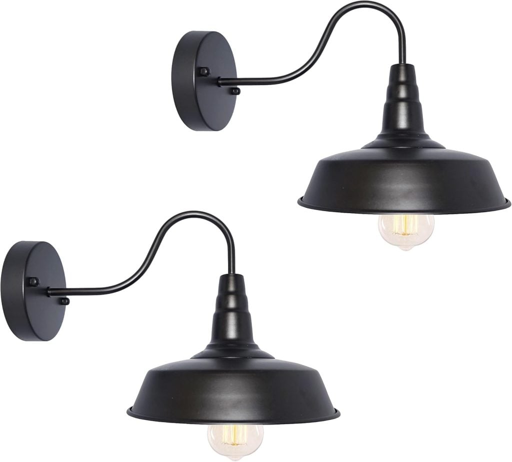 Two black metal wall sconces with exposed bulbs and curved arms are perfect for adding a touch of industrial charm to an Airbnb in Waco. Shown against a white background, they blend style and functionality effortlessly.