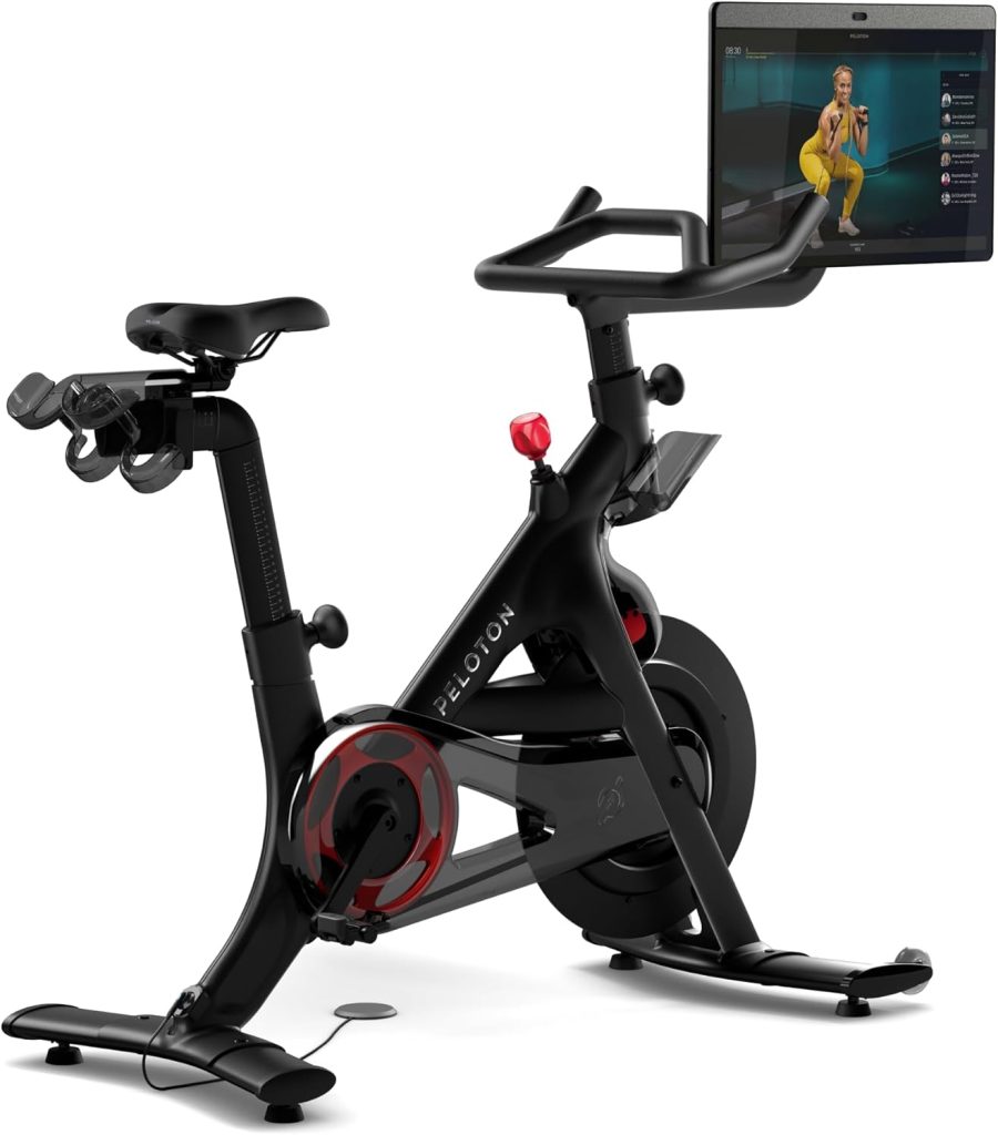 A stationary Peloton exercise bike with a screen streaming a workout session, much like an Amazon Prime video, delivering fitness at your fingertips.