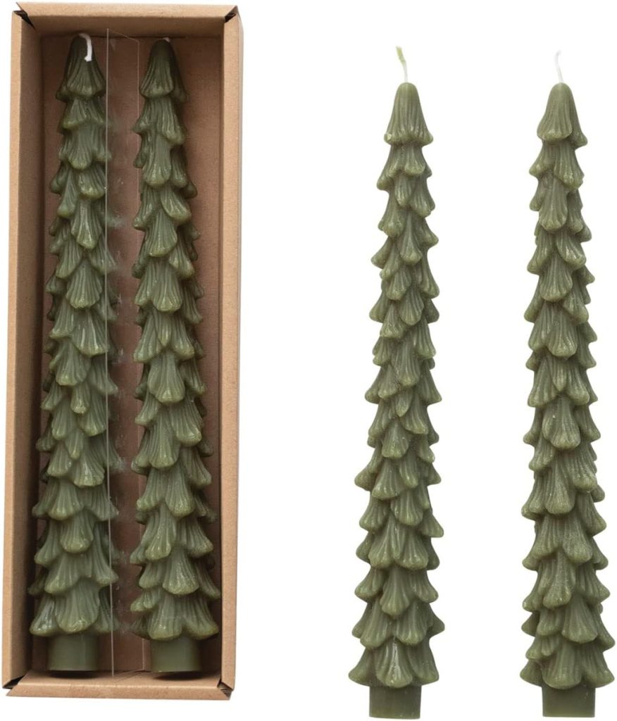 Two green tree-shaped candles with a textured design, alongside an open box containing two identical candles.