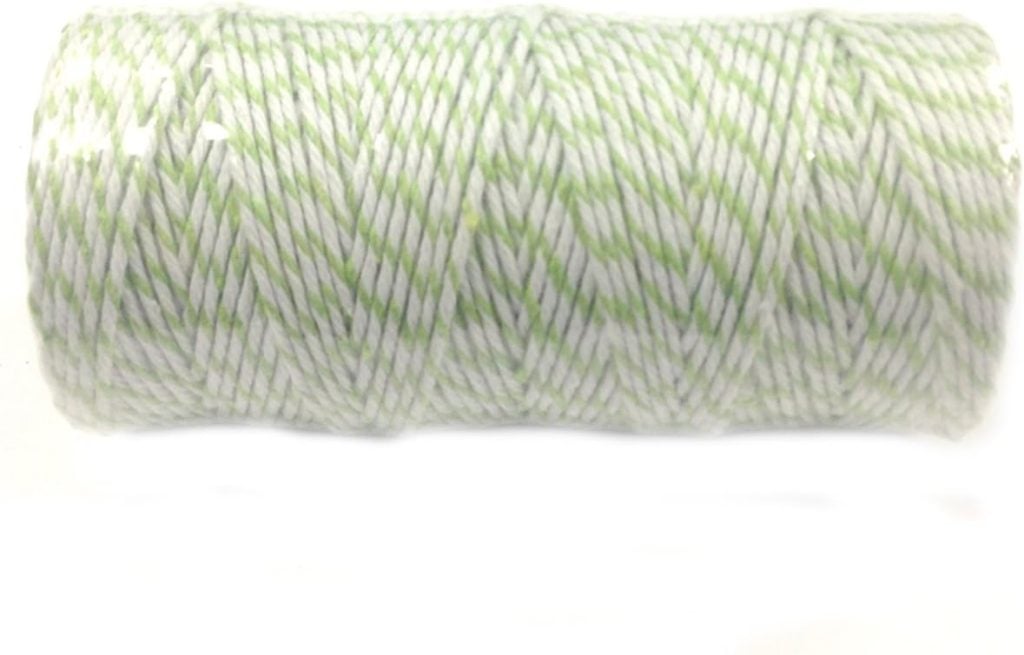 A spool of green and white twisted twine, shown horizontally against a white background.