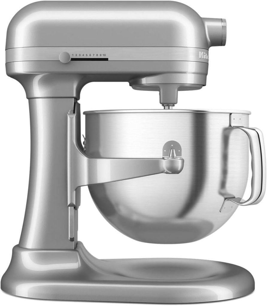 A silver stand mixer with a stainless steel mixing bowl attached and a speed control knob on the side.