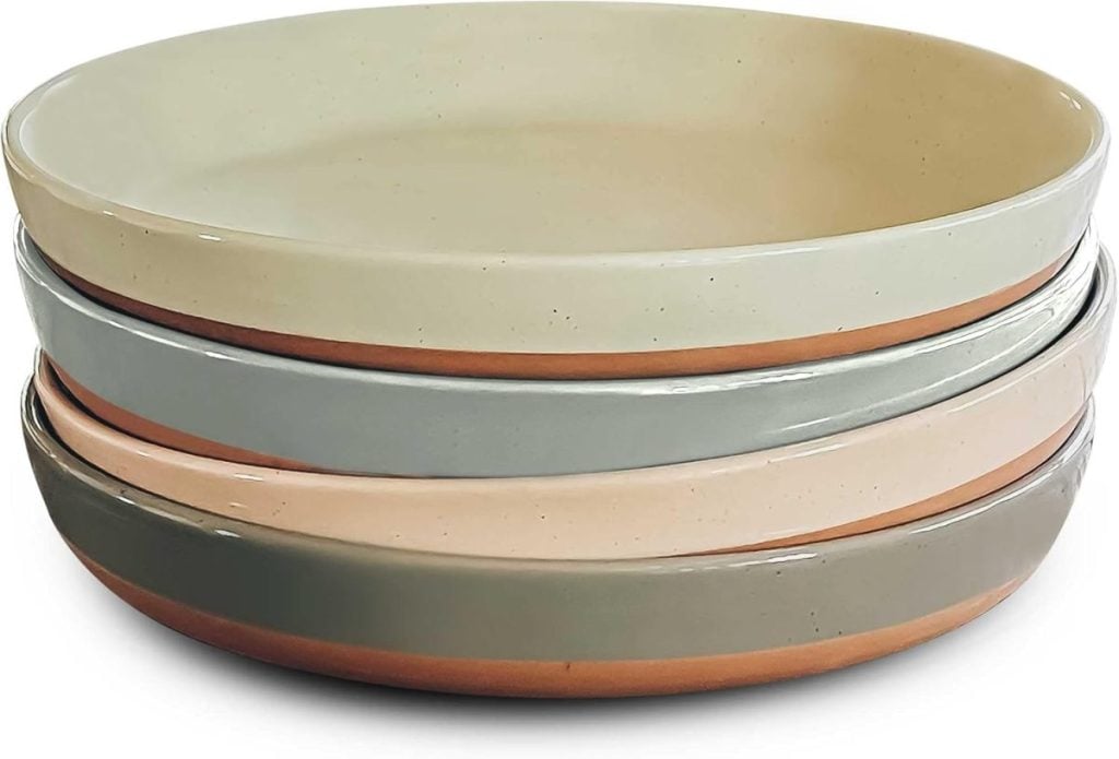 A stack of four ceramic plates in muted earth tones.