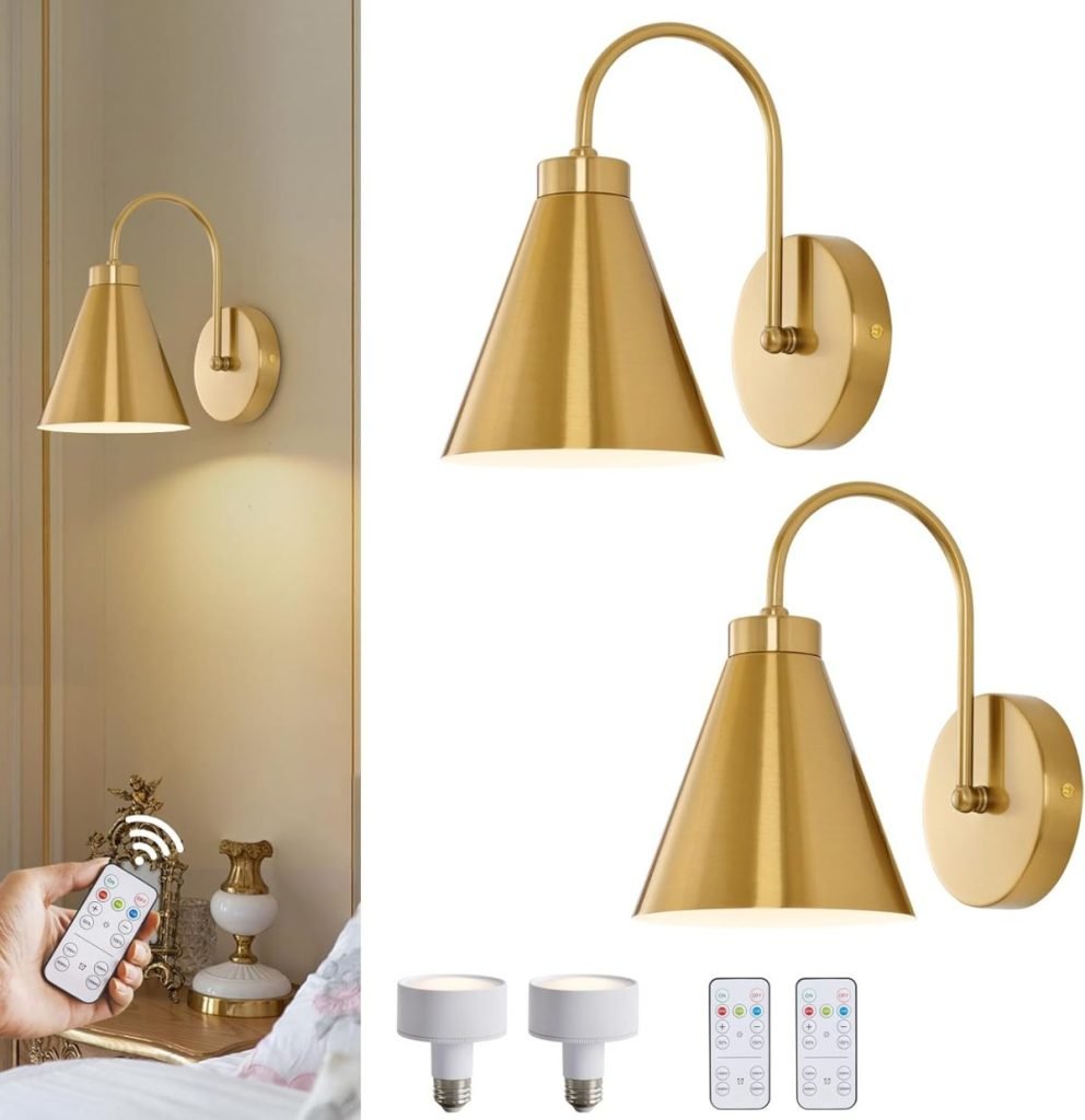 Two golden wall sconces with cone-shaped shades are mounted on a wall. The image also features two remote controls and two light bulbs. A hand holding a remote control is shown on the left side.