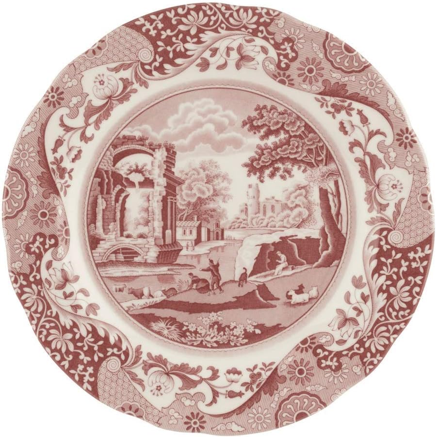 Decorative plate with a red and white pastoral scene featuring ruins, trees, sheep, and a person. Perfect for serving pie for breakfast, its ornate floral border enhances the central image.