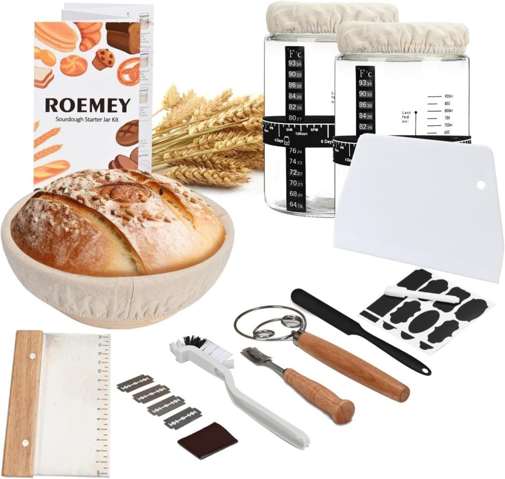 Sourdough starter kit featuring a proofing basket with bread, jars with temperature guides, a scraper, blade tool, brush, and booklet. Contains various baking tools and accessories.