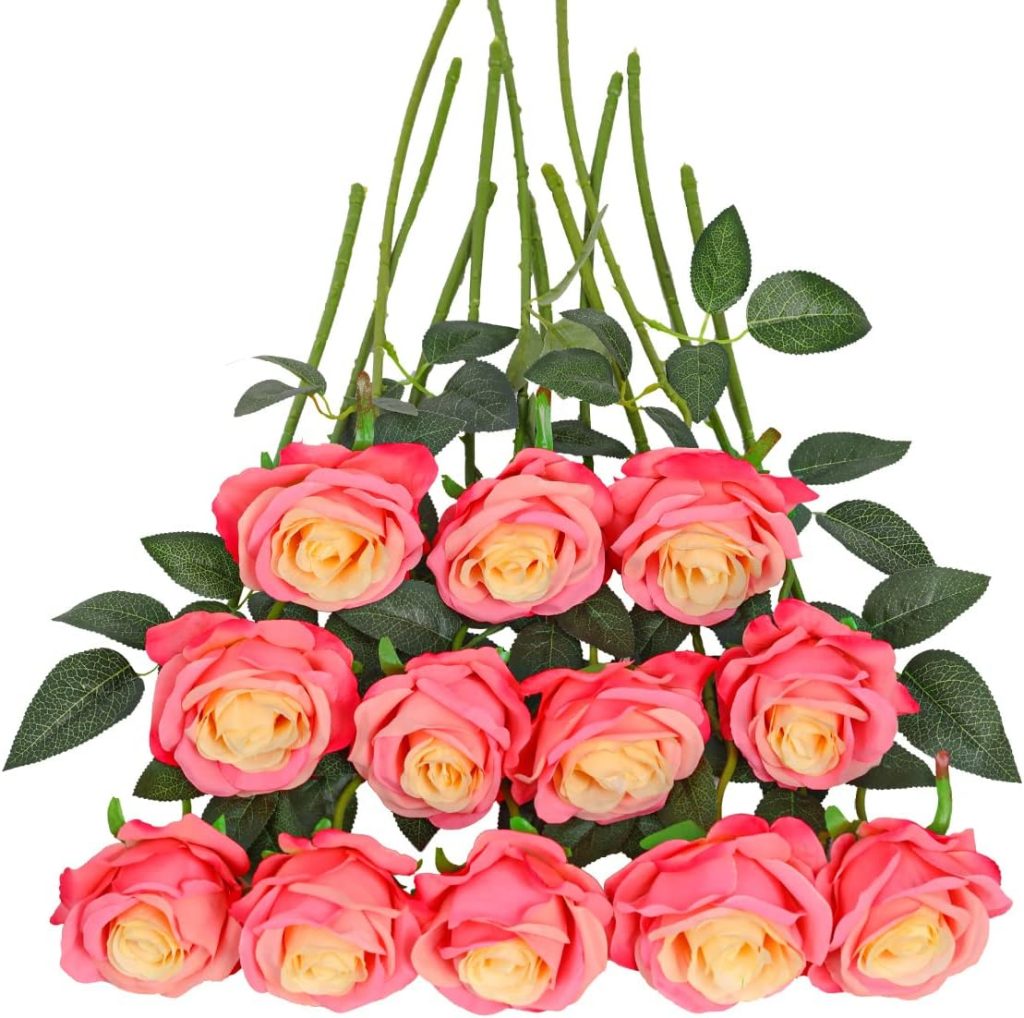 A dozen artificial pink and yellow roses, their green leaves and stems meticulously arranged in rows, complement the elegance of nearby glass water bottles.