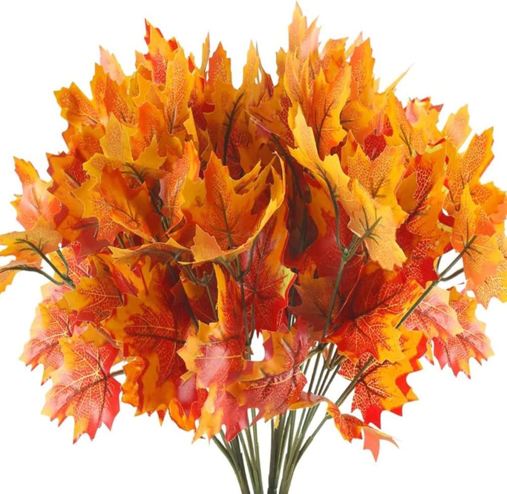 A bouquet of artificial autumn leaves in shades of orange, yellow, and red makes a perfect centerpiece, adding warmth and charm to your Friendsgiving table.