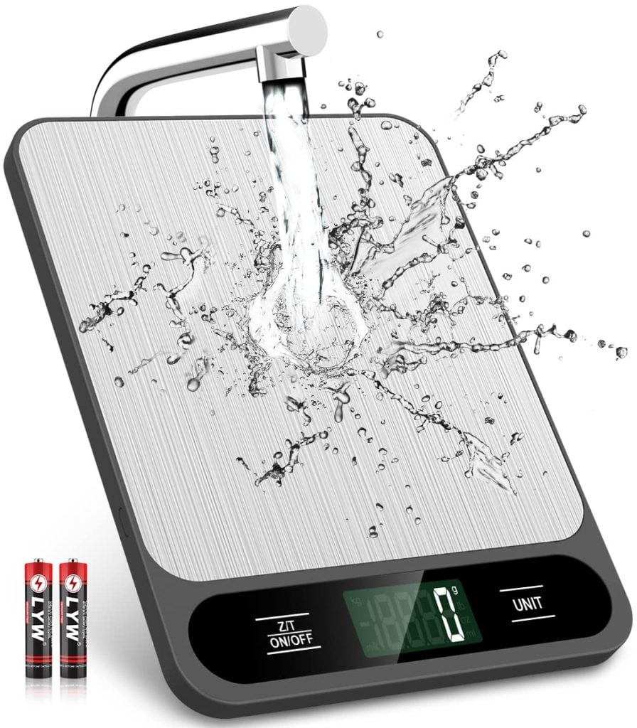 Digital kitchen scale with water splashing on it, displaying its waterproof feature. Two AA batteries are shown beside it.