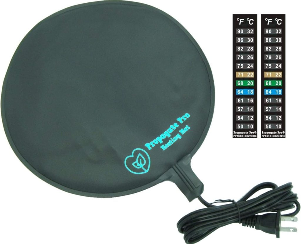 A round black heating mat labeled "Propagation Pro" with an attached electrical cord. A temperature conversion chart from Celsius to Fahrenheit is shown on the side.