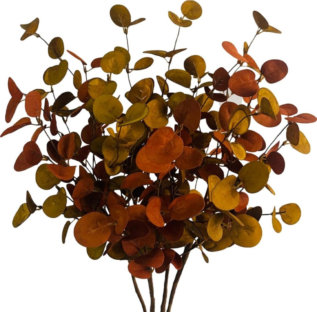 A bundle of eucalyptus branches with round leaves in shades of orange, yellow, and green evokes cozy autumn vibes—perfect for adding a touch of Pumpkin Craft charm against a crisp white background.