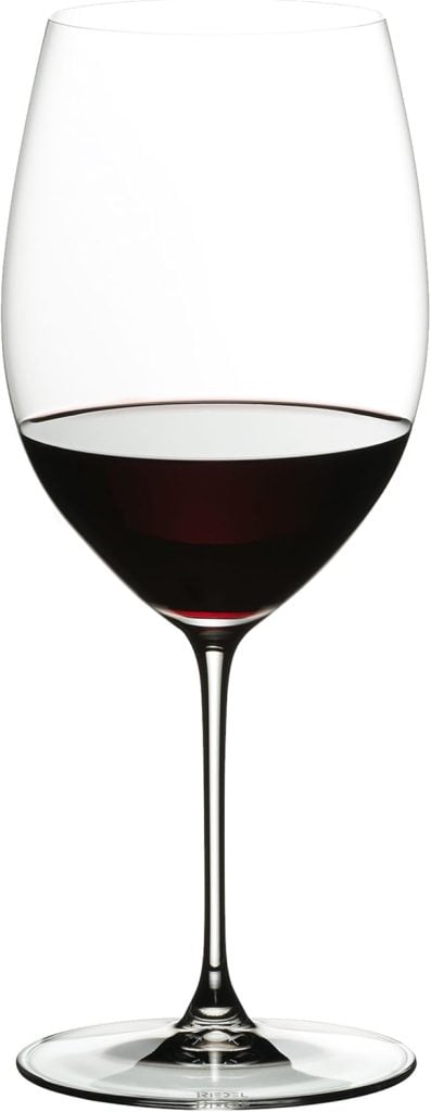 A tall wine glass filled halfway with red wine, set against a plain white background.