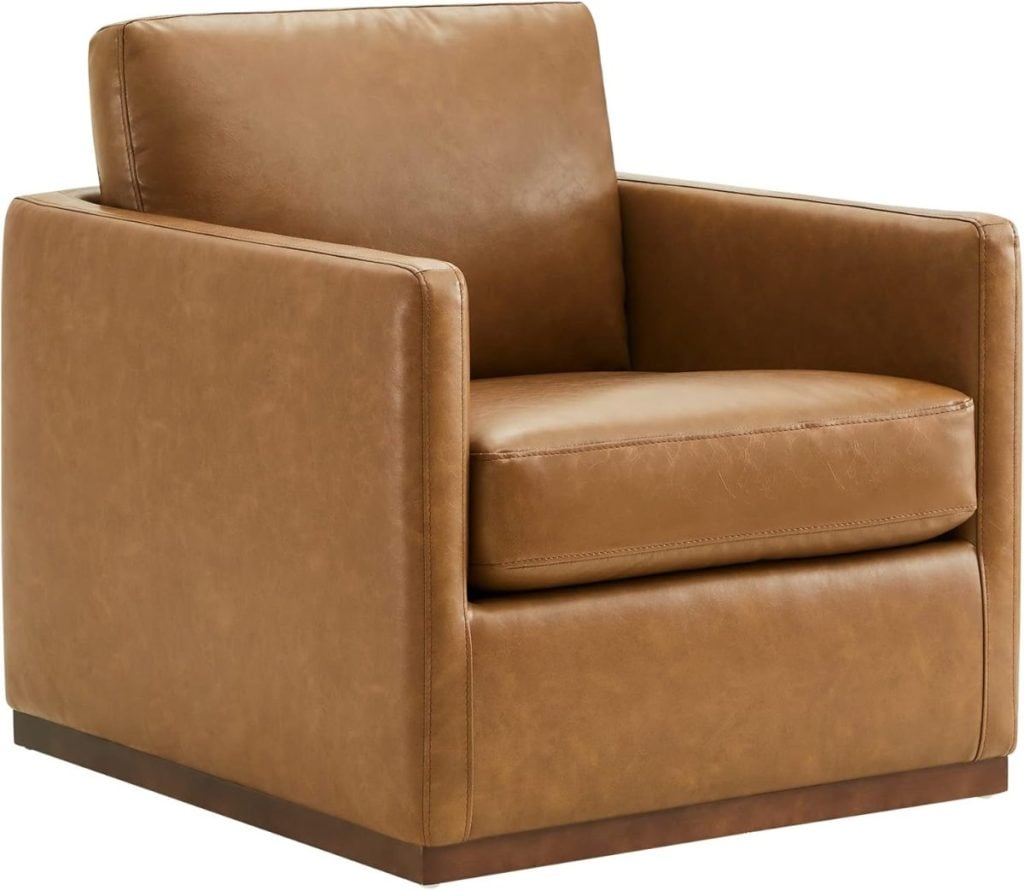 A brown leather upholstered armchair with a boxy design and a wooden base.