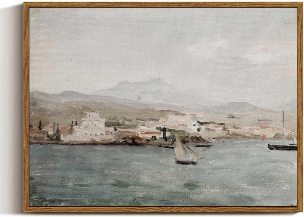 A serene seascape painting depicting a coastal town with distant mountains, a sailboat, and a ship on calm waters, framed in a wooden frame.