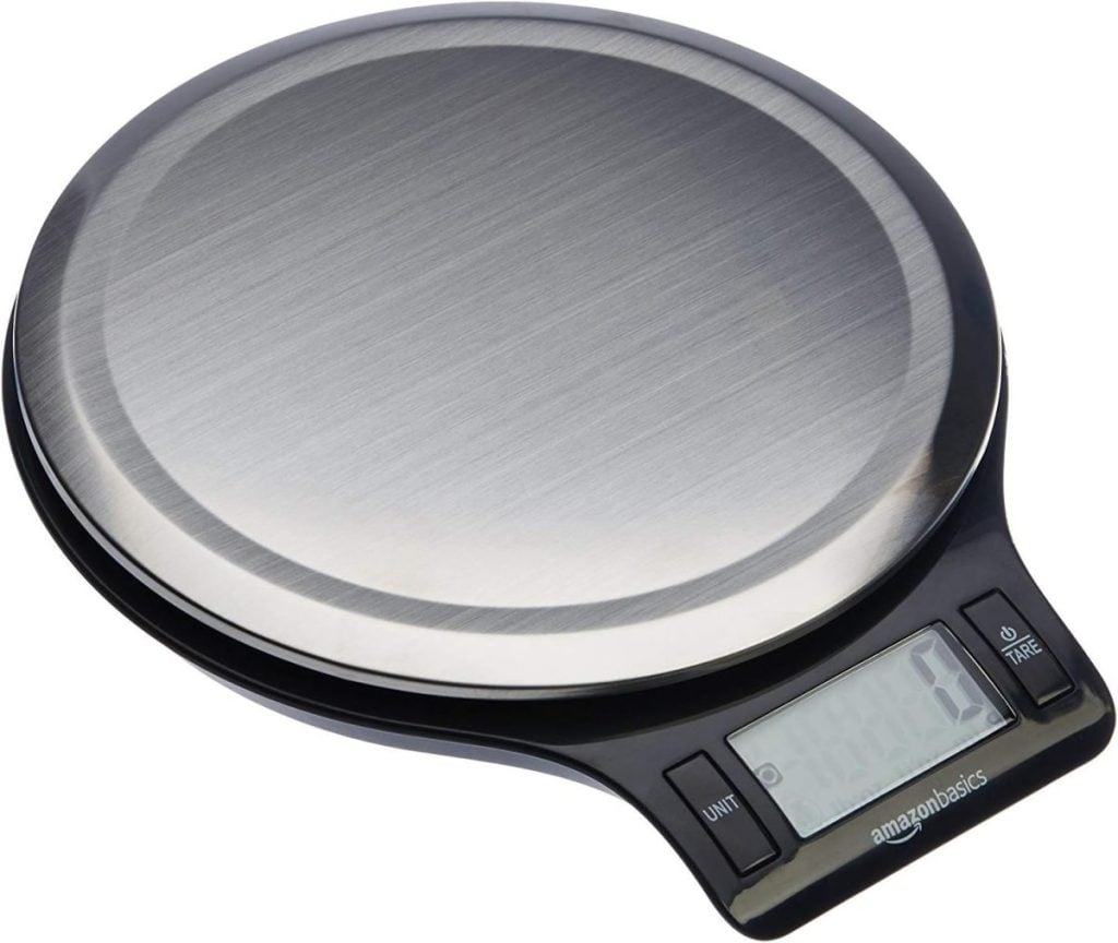 Digital kitchen scale with a round stainless steel weighing surface and an LCD display showing zero.