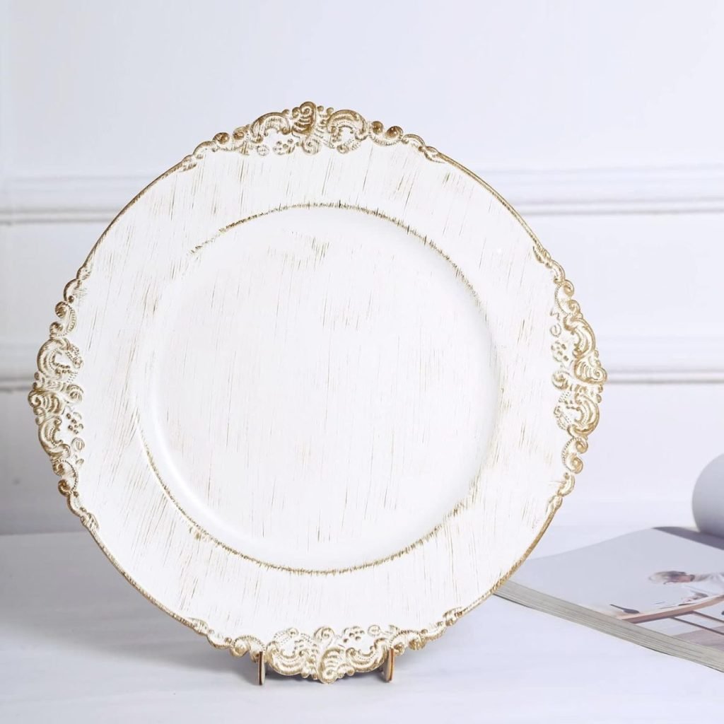 An ornate white decorative plate with gold trim, part of our exclusive Thanksgiving Plates collection, is elegantly displayed on a stand beside an open magazine.